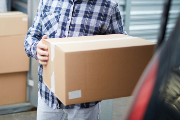 Man putting box in trunk